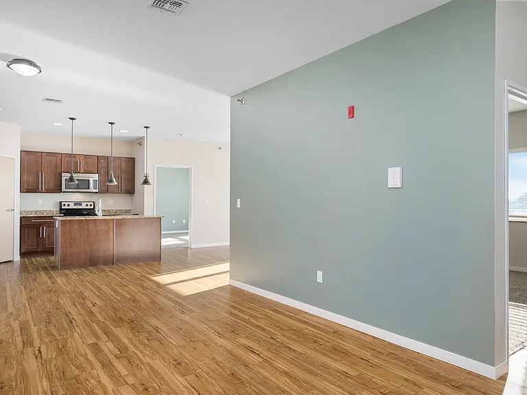 Modern open-concept apartment with hardwood floors, featuring a kitchen with granite countertops and stainless steel appliances. Modern open-concept apartment with hardwood floors, featuring a kitchen with granite countertops and stainless steel appliance