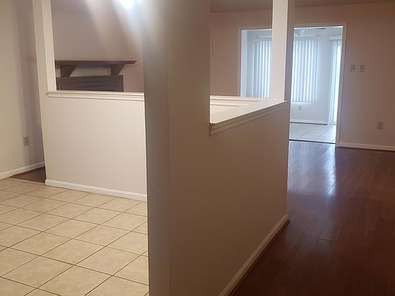 Entry hall with living room ahead, kitchen on right, coat closet to the left.