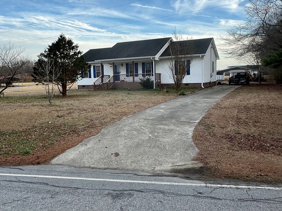 The concrete drive leads to covered carport. newly stained front porch.