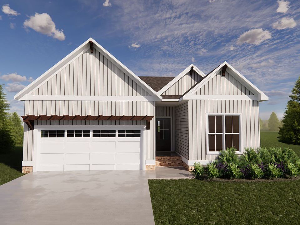 White single-story house in Poplar Village with a gabled roof, garage, and front garden under a blue