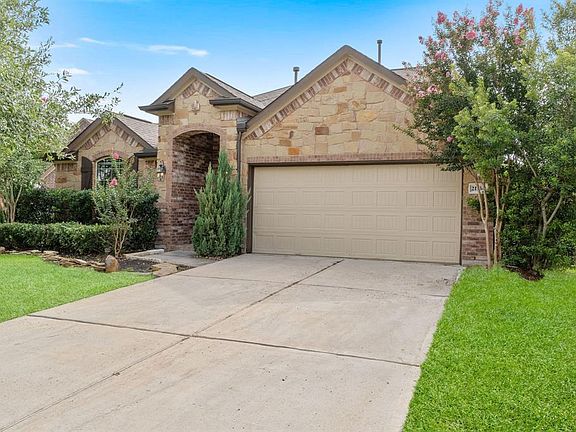 Lush landscaping and brick and stone details give this home great curb appeal.