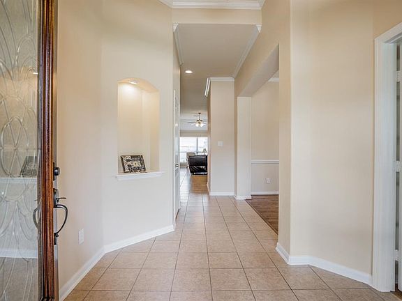 The leaded glass and mahogany front door invite you to enter into a tiled foyer with neutral paint tones.