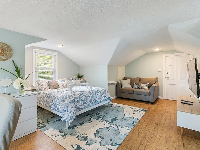 Cozy living area with comfortable queen bed and seating space for relaxing or entertaining.