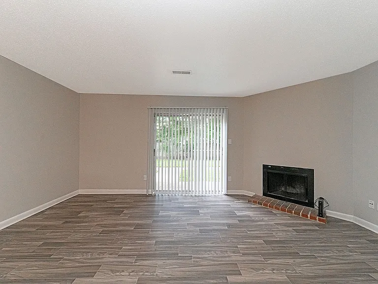 Spacious living room with hardwood-style flooring & fireplace