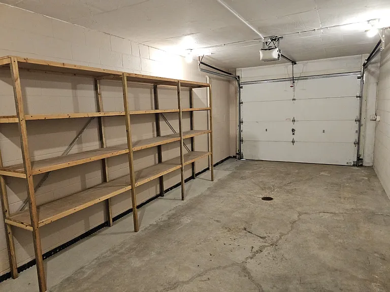 One car garage with shelves for storage.