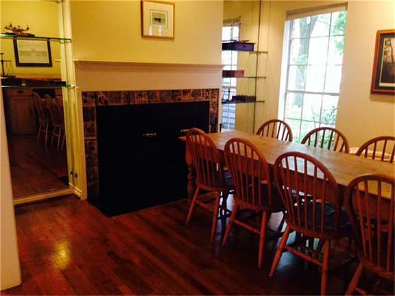 Formal living room with wood burning fireplace. Pine table and chairs are for sale. Built-in cabinet