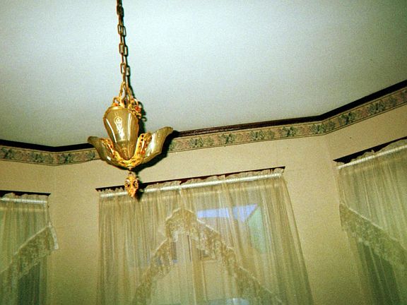 This is another view of the front windows with more traditional curtains. This first living area is entered through an archway from the front door.