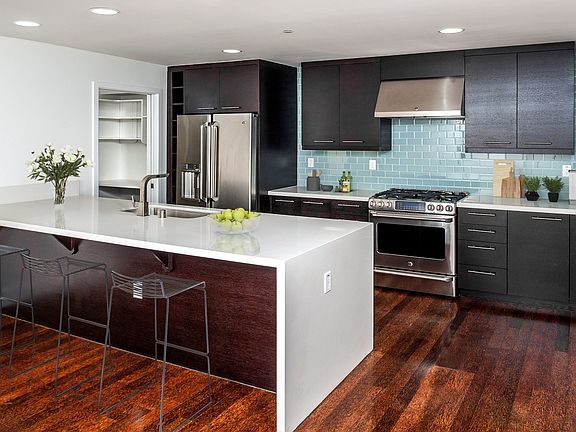 Designer kitchens with quartz countertops, stainless steel appliances and a breakfast bar