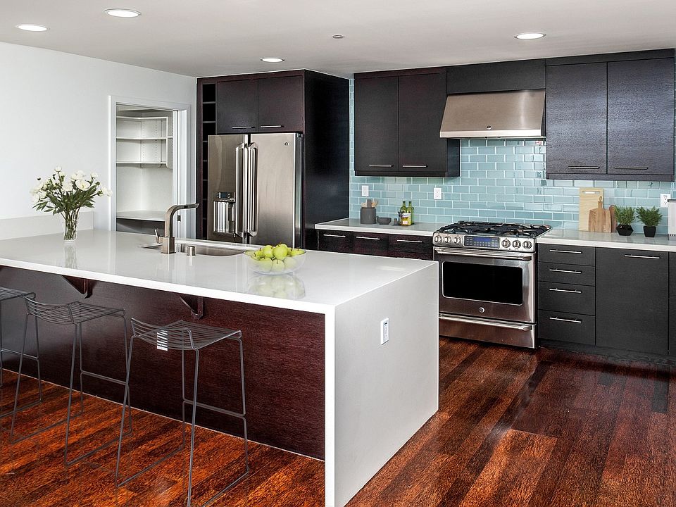 Designer kitchens with quartz countertops, stainless steel appliances and a breakfast bar