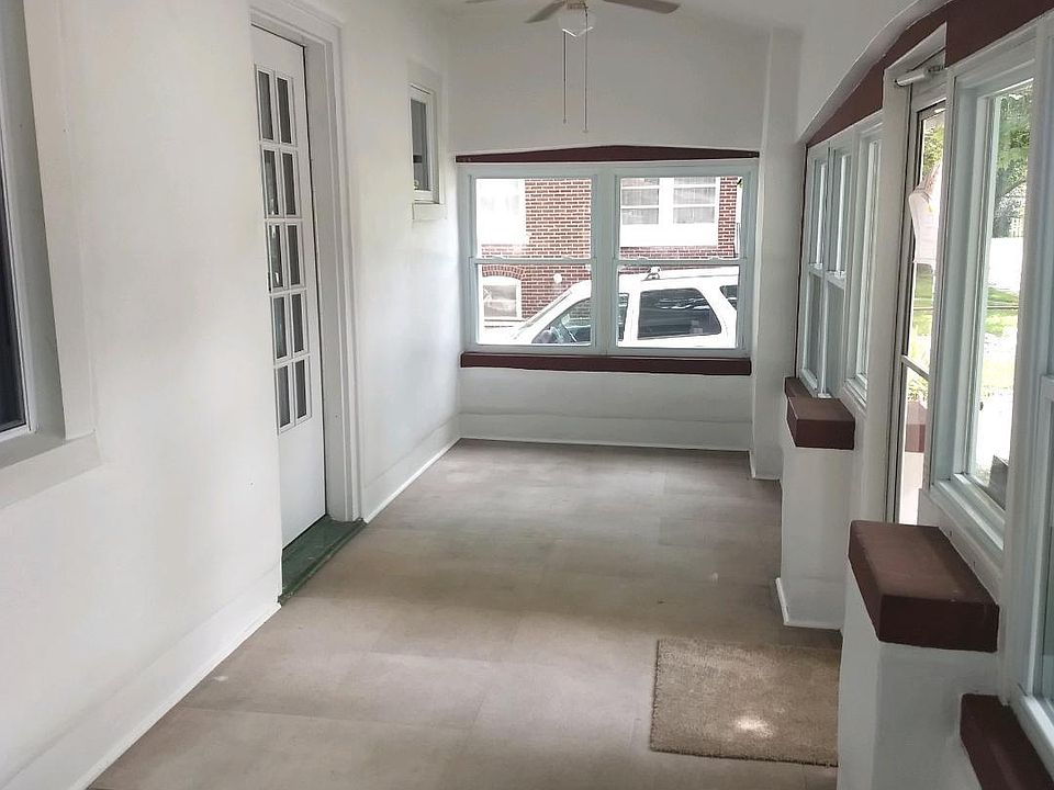 NICE ENCLOSED FRONT PORCH WITH CEILING FAN AND NEW WINDOWS.