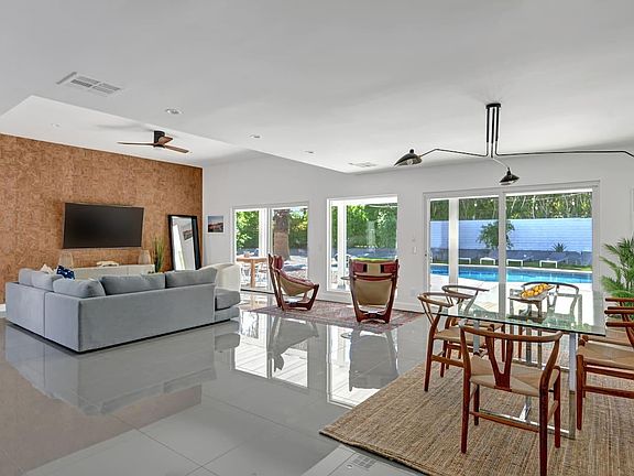 open plan living / dining room / porcelain flooring / view of expansive pool area