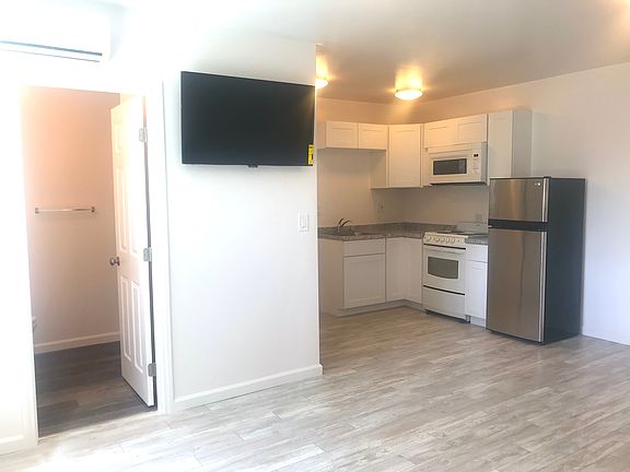 Full kitchen with oven, microwave, and fridge. TV wall-mounted and included.