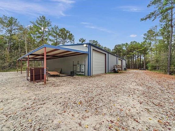 The south end fully covered 60x16 exterior. 2 foot plus of Bull rock and crushed concrete raised driveway and building perimeter Two of the over heads doors.