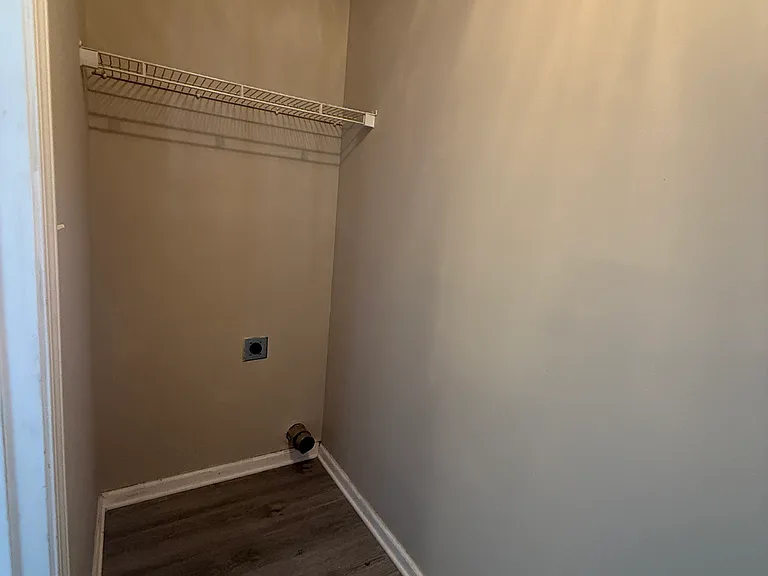 Dedicated laundry room equipped with a handy built-in storage shelf for laundry essentials.