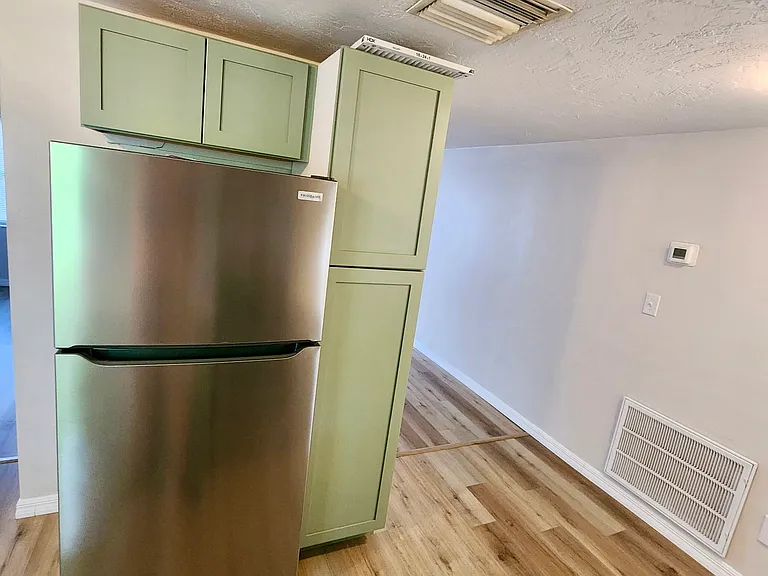 Kitchen with stainless steel appliances (refrigerator & oven).