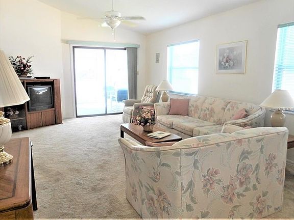 Carpeted Living room leads to the screened lanai.