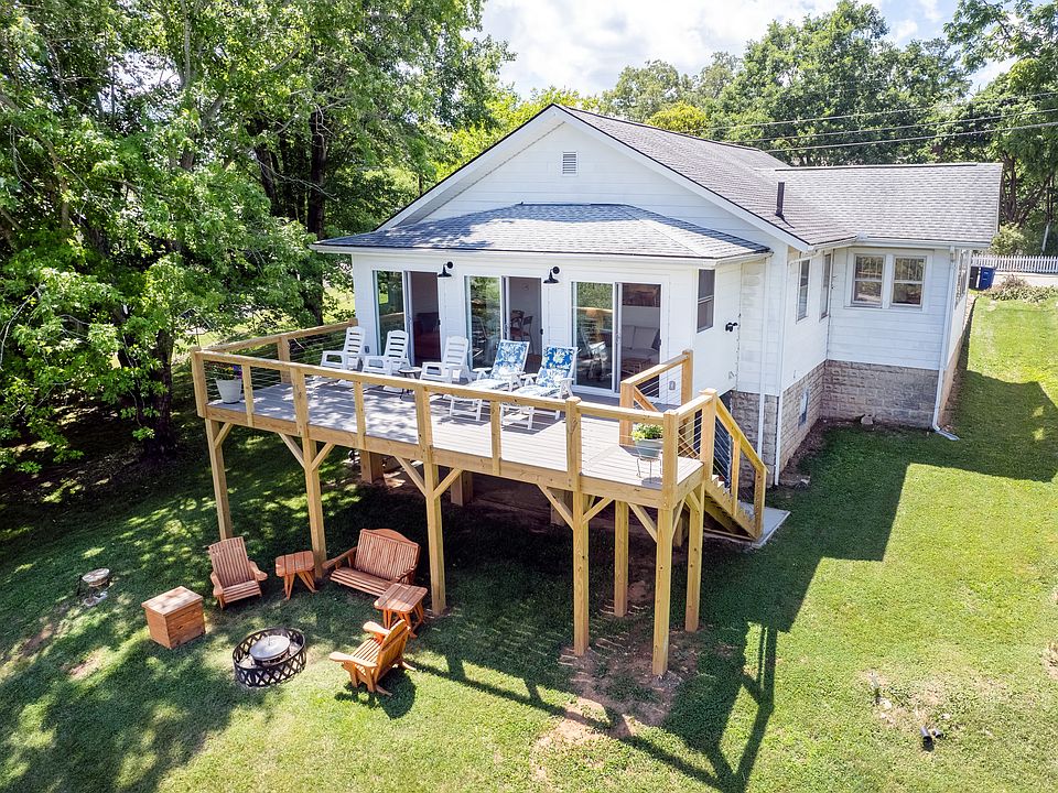 Gorgeous deck overlooking a rolling acre of grass and trees with layers and layers of mountains in the distance.