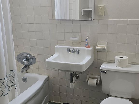 Full bathroom with storage shelves.