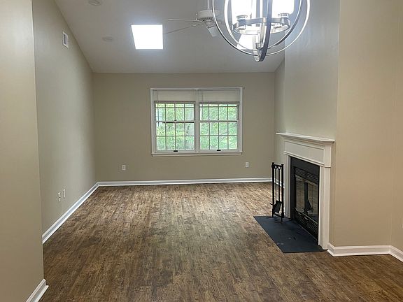 View from the kitchen of the dining area and the living room with wood burning fireplace -- to the left is the primary bedroom with walk-in closet and full bath