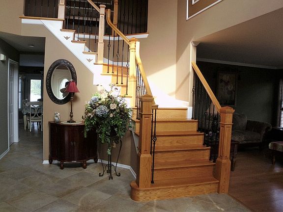 Stunning 2 story foyer with Oak & Wrought Iron Staircase.