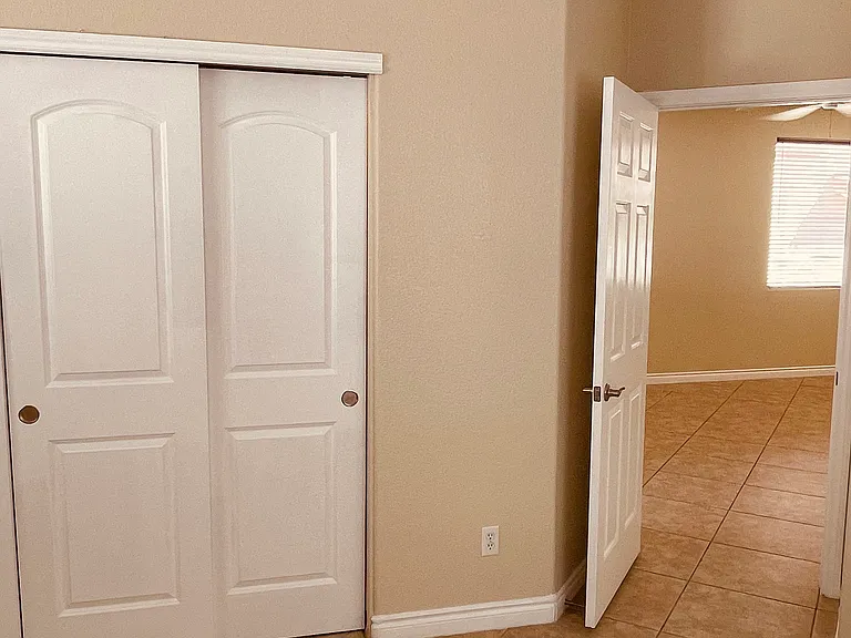 Master Bedroom has Ceiling Fan, Sliding Closet Doors and Master Bath. Bedroom Door Opens to Living Room.
