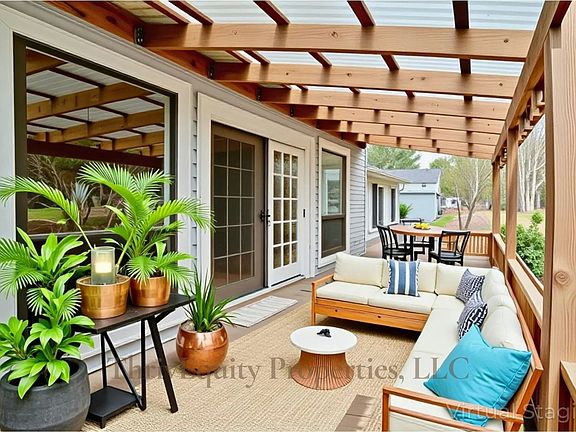 Covered back deck with room to relax, dine, and enjoy peaceful backyard views.