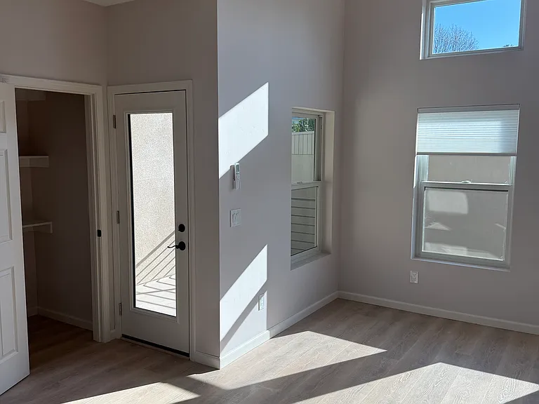View of pantry and balcony door in living area with tons of natural light