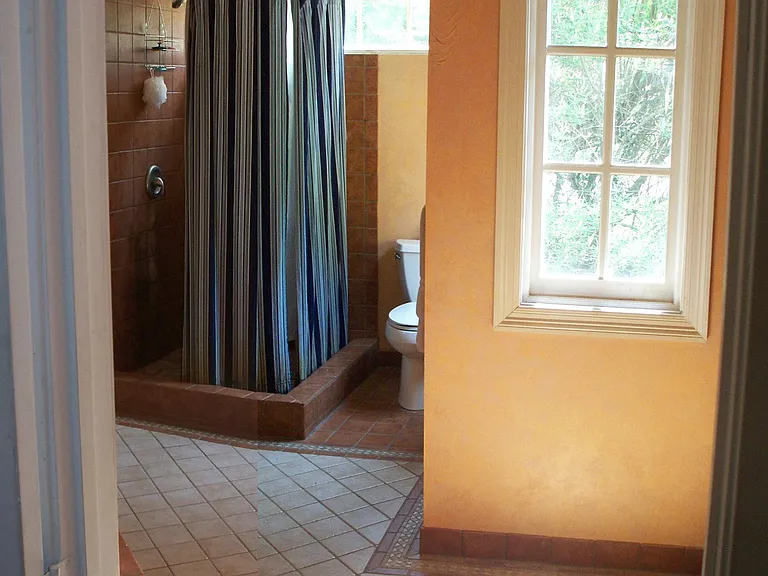 Another View of the Upstairs Master Bath, showing the Palladian Window and shape of bathroom. ( Bathroom sink is to the right, and the whirlpool tub is to the left.) Small window at toilet is shielded by view of large, mature trees. Has cafe style curtain