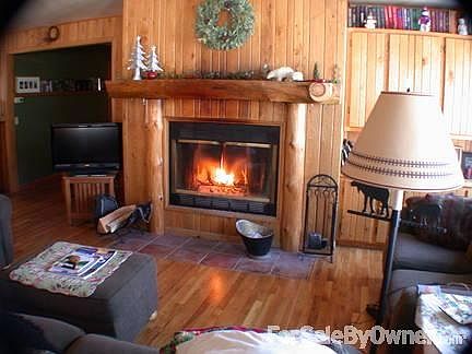 Great room with log mantle fireplace
						:
						Oak plank paneling adds a rich touch.