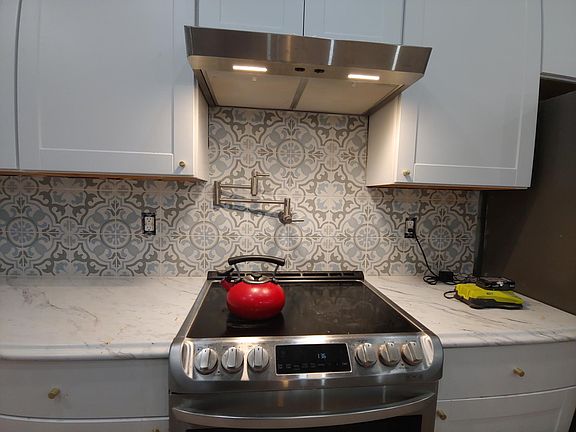 Smooth surface cooktop with pot filler