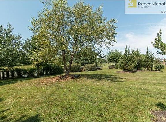 Mature trees in fenced yard.