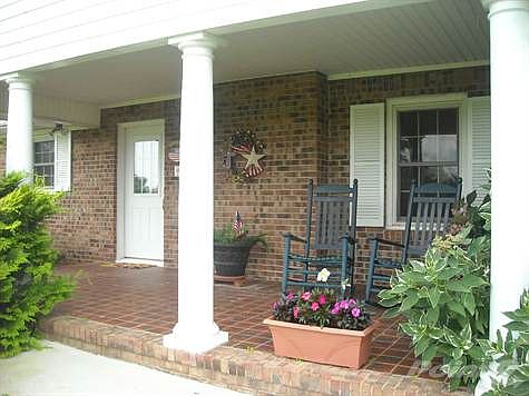 Serenity is the mood of this brick front porch... the perfect setting for a quiet afternoon of readi