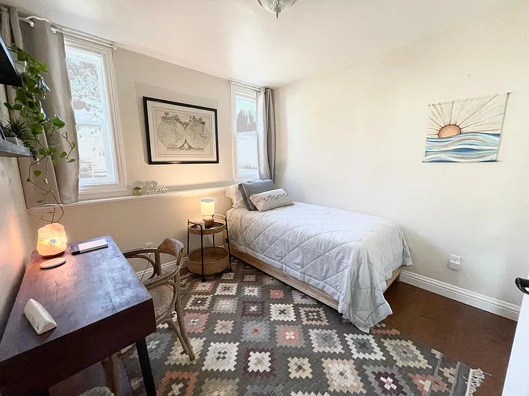 2nd bedroom/office with twin bed, desk and wall shelves