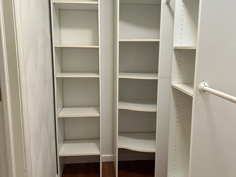 large walk in master closet with real wood flooring