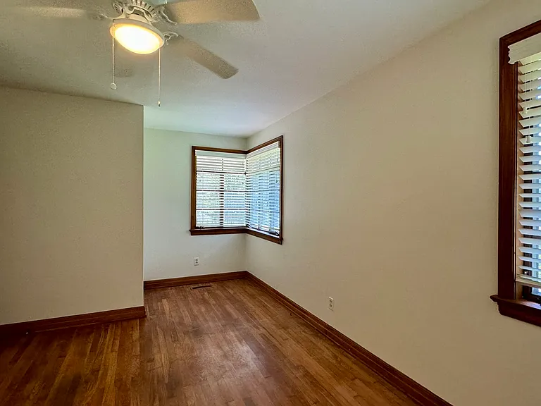 Bedroom 1 with hardwood flooring.