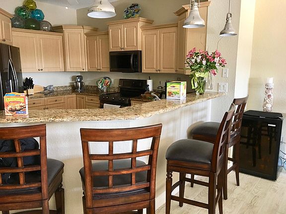 Kitchen with newer black stainless appliances and bar area.