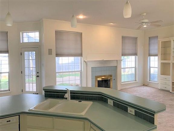 Large gourmet kitchen looks out to beautiful backyard with abundant shade trees and newly installed Saint Augustine grass.