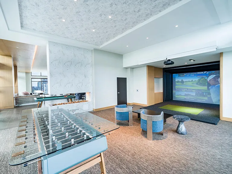 A resident lounge featuring a Full Swing Golf simulator creates a social setting for play and connection.