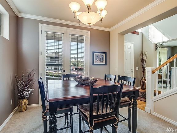 The formal dining room features tall French doors accessing the covered front balcony. Enjoy leaded glass accent windows here as well.