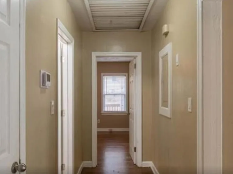 Back hallway that connects bedrooms 2 & 3 with the bathroom in between. Awesome working whole house vent overhead.