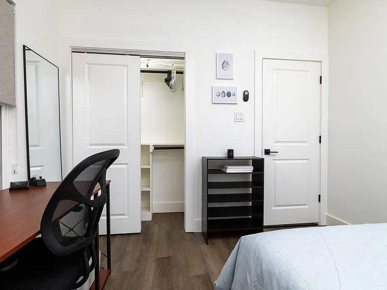 Designated workspace in the third bedroom featuring wooden desk and ergonomic chair.