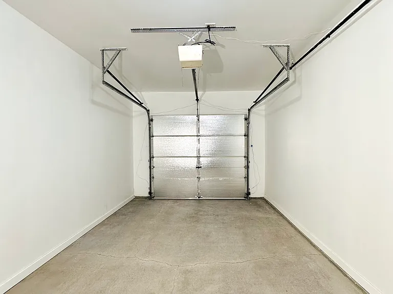 Spacious garage with fresh paint and floor.
