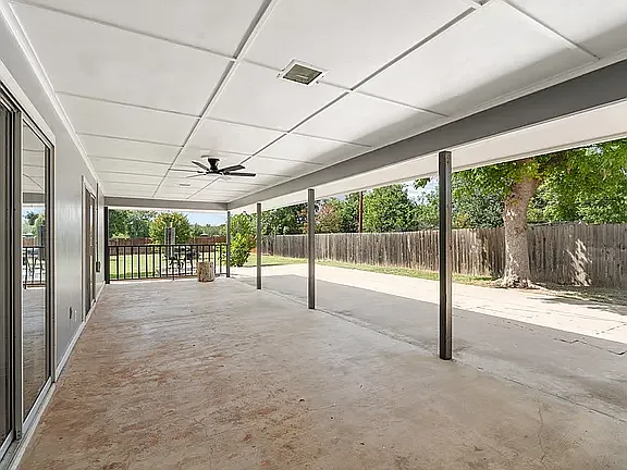 Huge entertaining patio with ceiling fan overlooking shuffleboard court