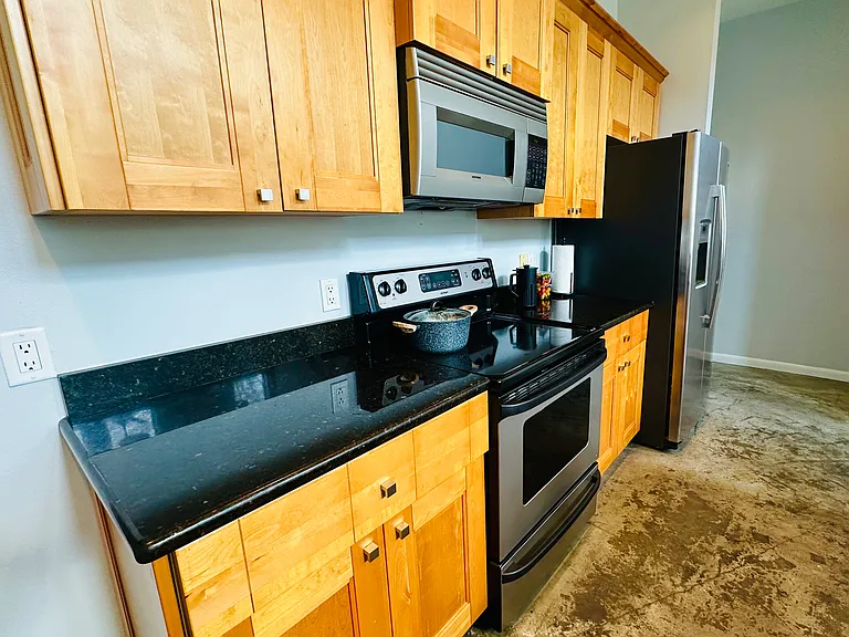 European Wood Cabinets, Granite Counters, Stove, Refrigerator w/ water dispenser and Microwave