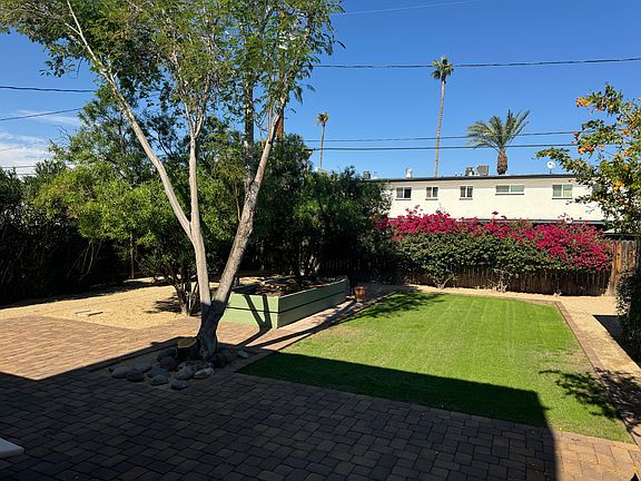 Backyard with raised garden, patio area and grassy area.