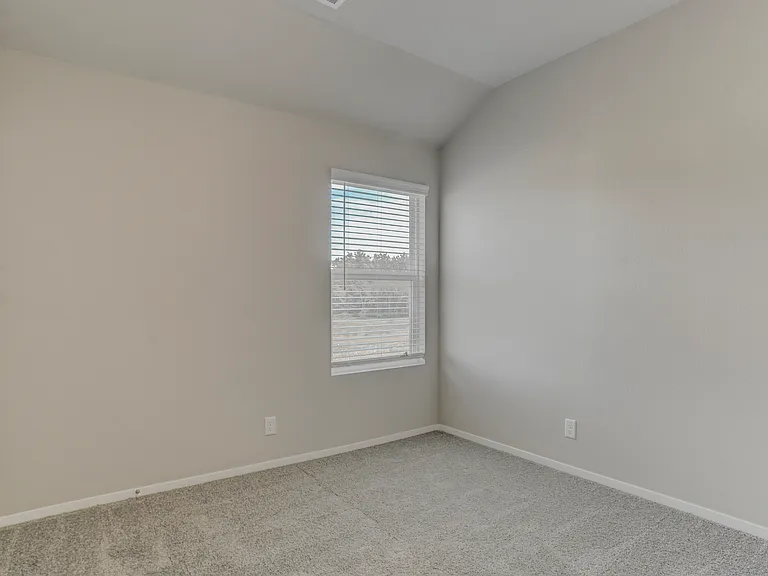 Looking into the bedroom next to the living room and the bathroom. Bedroom 2 of 4