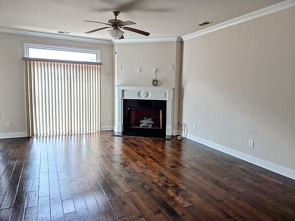 Spacious, open concept living room with fireplace and gleaming wood floors
