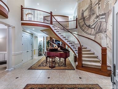 The cedar covered front entry leads to the striking voluminous foyer with an impressive floating cherry staircase and custom hand painted wall mural. 