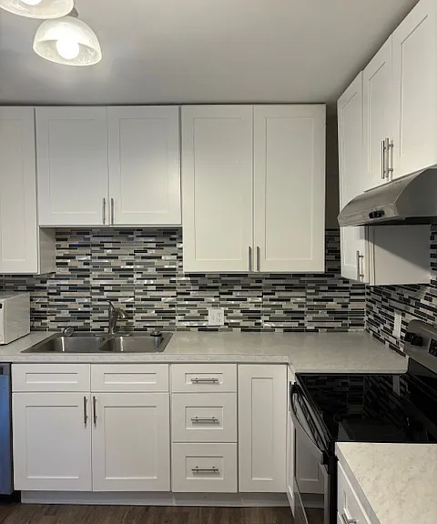 Kitchen with gas range and vent hood.
