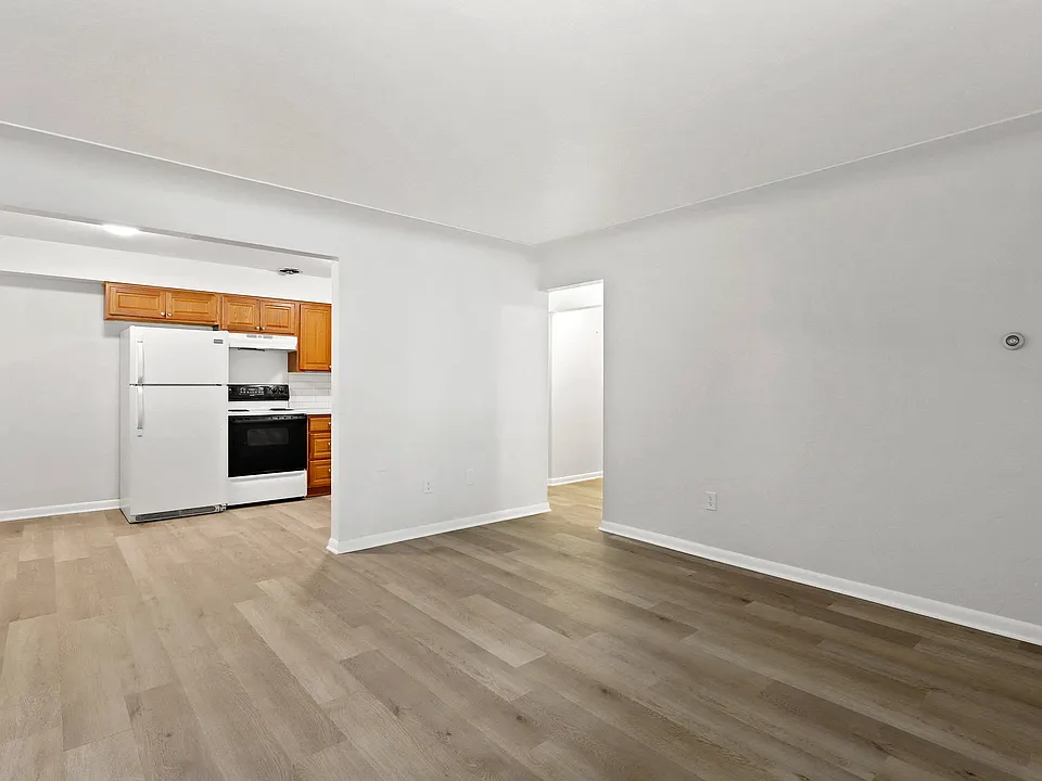 Bright and inviting kitchen area with wooden cabinetry, white appliances, and elegant flooring, perfect for a modern lifestyle.